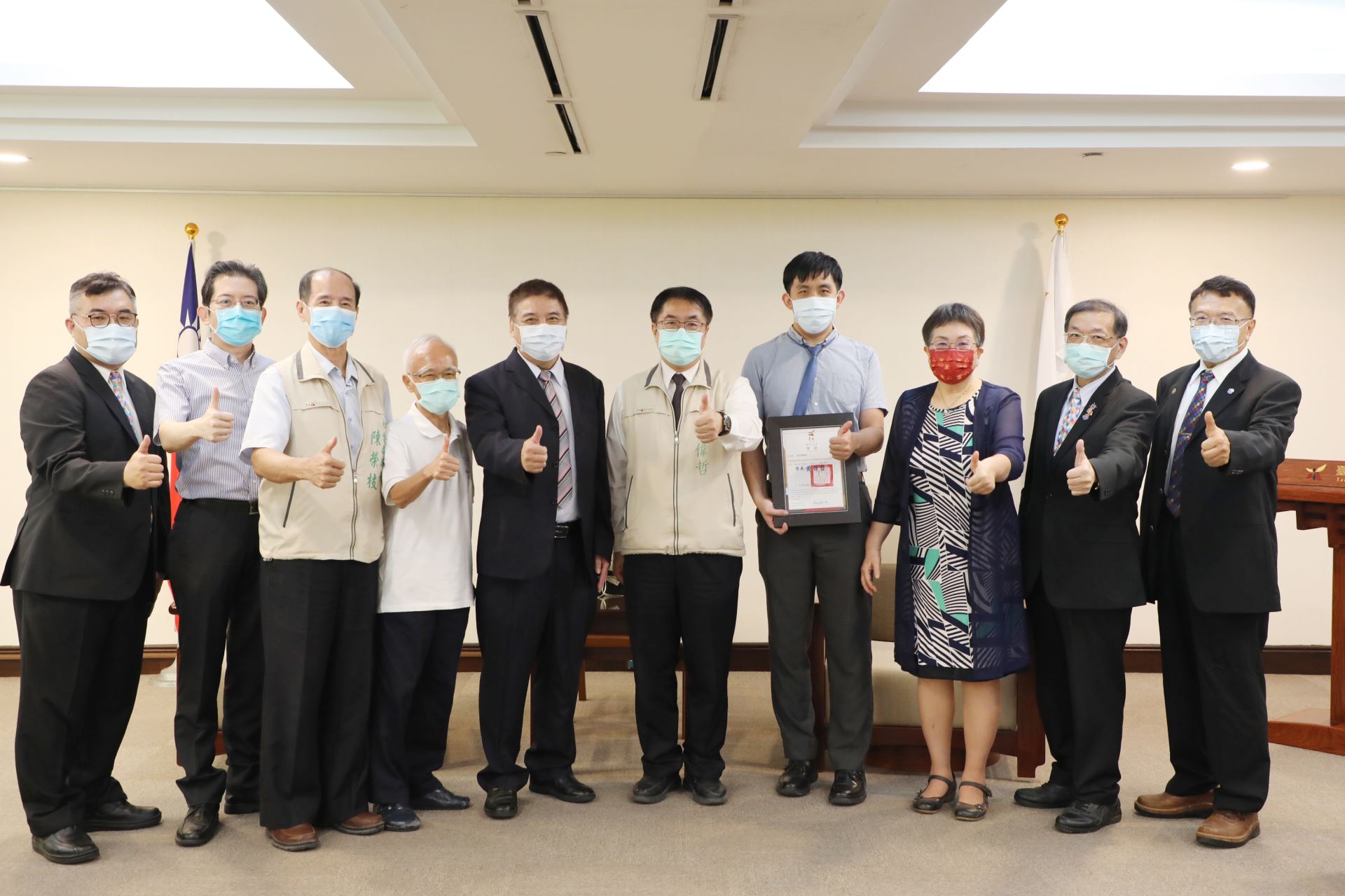 Tainan City Mayor Huang Wei-Che awarding and taking a photo with Doctor Chou Meng-Leo.