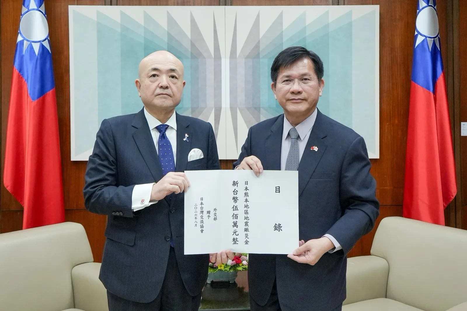 外交部長林佳龍（右）向日本台灣交流協會台北事務所代表片山和之（左）遞交我國新台幣500萬日元賑災款捐款目錄。