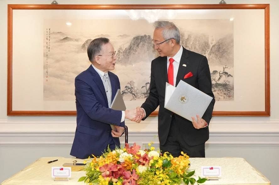 外交部政務次長吳志中與「台灣永續能源研究基金會」董事長簡又新於簽署合作備忘錄後握手致意。