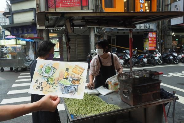 全台僅存用碳火烤豌豆的攤車,目前接手做的孫女看到鄭開翔的畫,直呼:「怎麼把我畫得這麼像。」(林格立攝)
