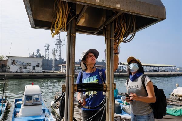 Team members confirm that a harbor has the onshore electrical connections that they need to power their “ocean vacuum.”