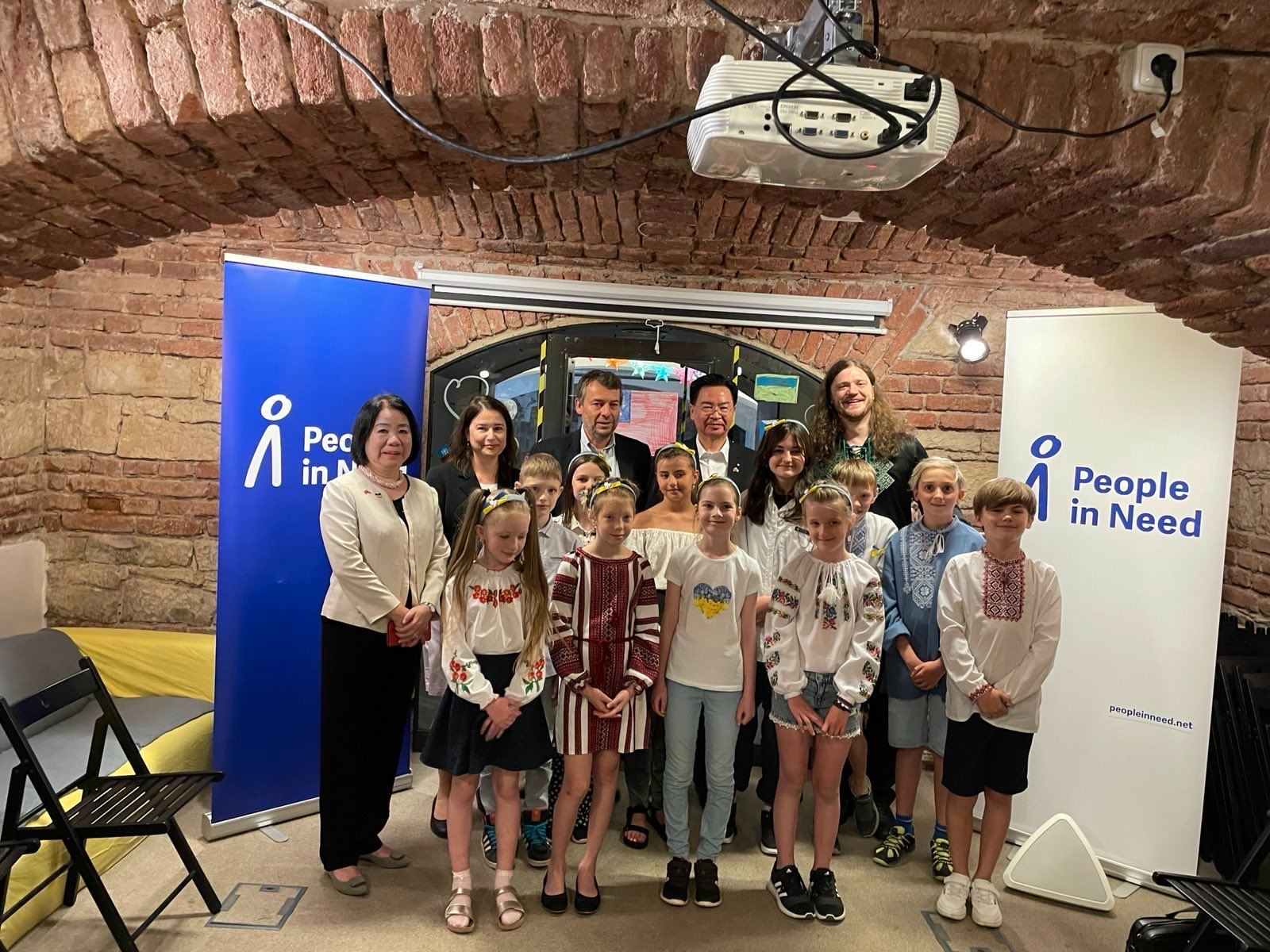Foreign Minister Joseph Wu (second right in the back row) is pictured with Ukrainian children in the People in Need headquarters on Wednesday in Prague.