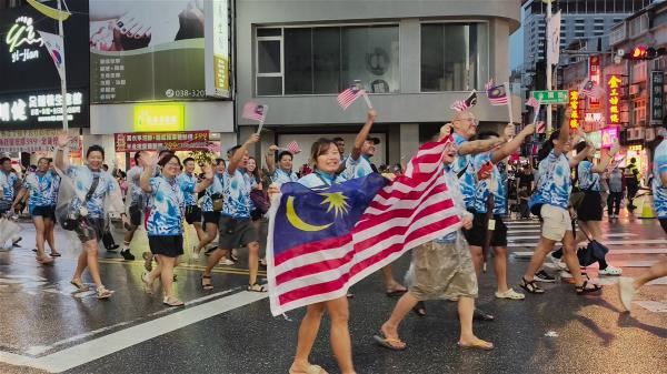 賽事前夕的踩街活動，各國選手於花蓮市區歡樂遊行，與熱情民眾揮手互動。（花蓮縣政府提供）