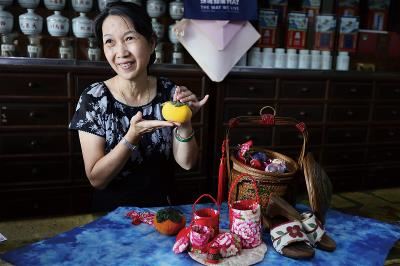 Lai Shuzhen, granddaughter-in-law of the founder of De’an Tang Traditional Chinese Medicine Pharmacy, uses patchwork cloth to make miniature “gratitude baskets” and other cultural items.