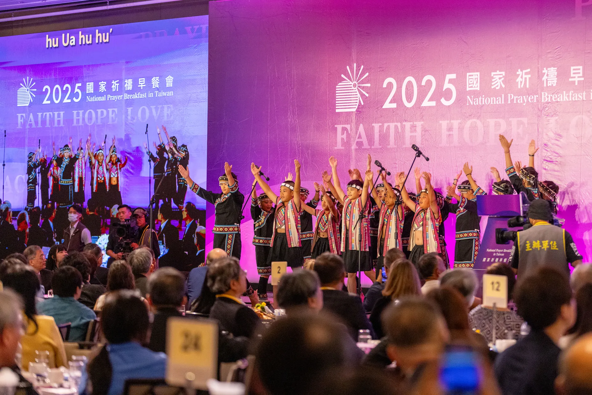 身穿著布農族服的17位小朋友在國家祈禱早餐會獻唱，清亮的泛音式複音合唱極具穿透力。族曲歌詞傳遞「用更大的決心、更多能力共同守護族群，互敬互愛，祈願國運平安」（照片提供：台灣世界展望會）