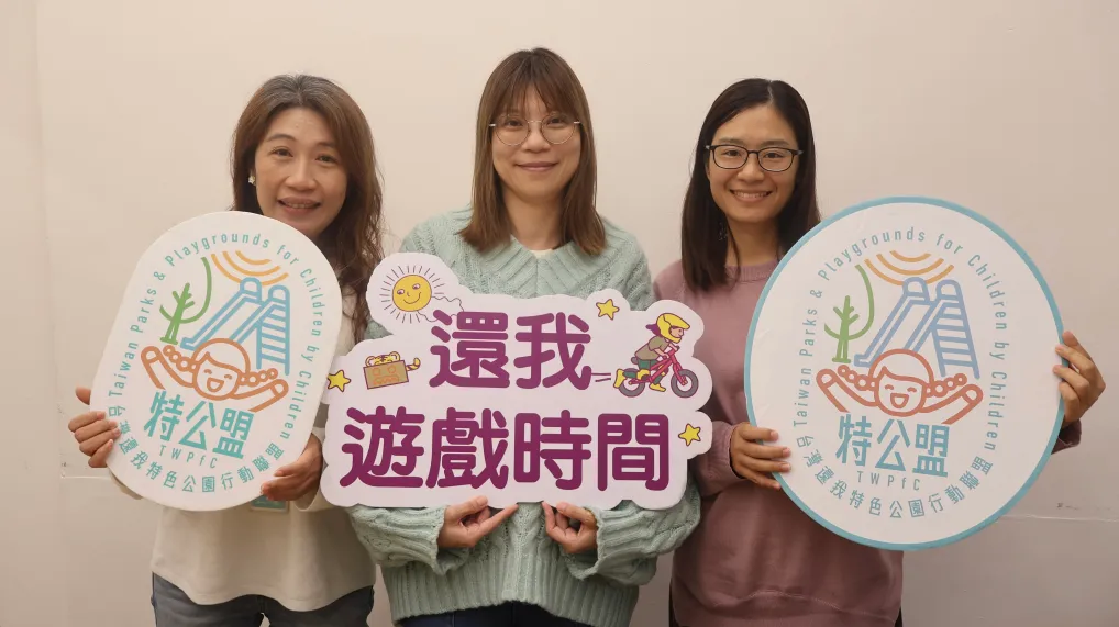特公盟成員鍾欣潔（左）、王秀娟（中）、林珦如（右）手持倡議標語，希望社會重視兒童遊戲權並推動具參與性的公共遊戲空間。攝影／李孟蓁