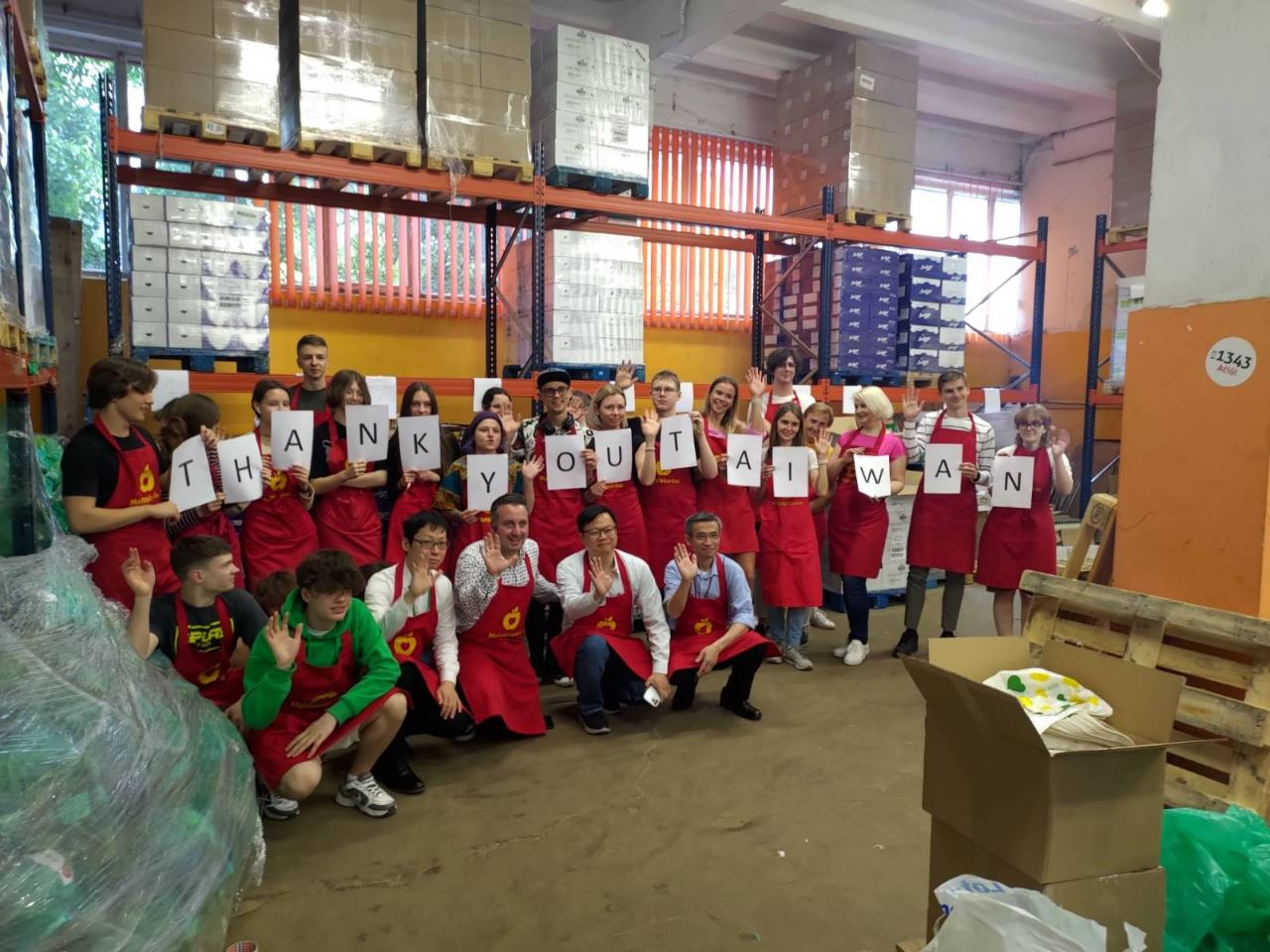 黃鈞耀代表偕同仁與「立陶宛食物銀行」執行長居里維休斯及手持「感謝台灣」文字的義工合影