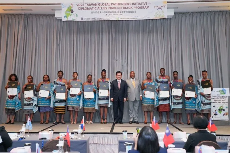 Foreign Minister Lin Chia-lung (seventh right) and Eswatini Amb. Promise Sithembiso Msibi (sixth right) line up for photos with 12 youths from the African ally at the closing ceremony of the training session July 31 in Taipei City. (MOFA)