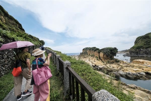 遊客沿著步道飽覽奇特的海蝕地景。