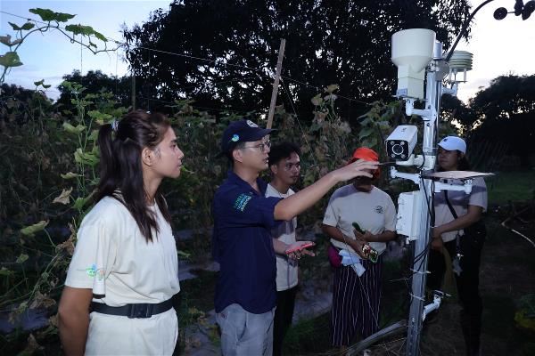 技術團架設了氣象站，收集田間的數據，彭元慶（藍帽者）會召開檢討會，為農民解說分析，用數據說話。