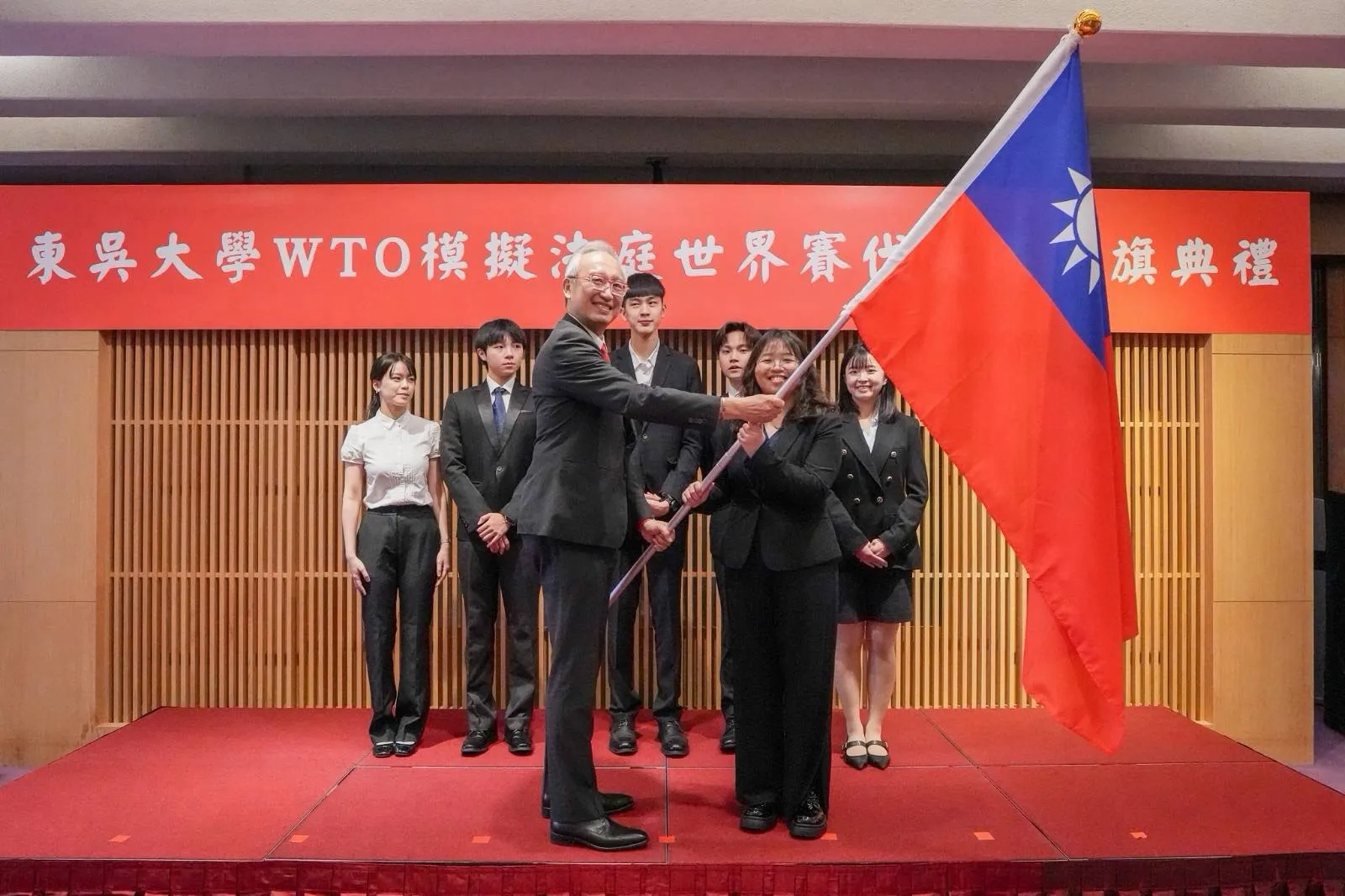 外交部政務次長吳志中授旗予代表隊秦懿楦同學並為代表隊加油打氣。
