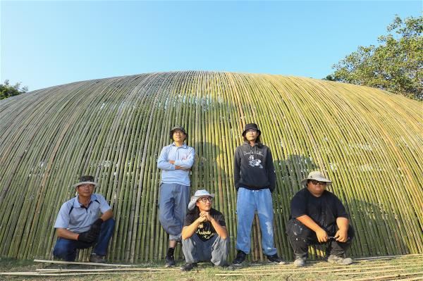 Chen Yu-lin (center), Chen Yu-ting (second from right), and their team from YuYu Art Studio hope to shine a spotlight on their hometown by enlivening it with art. Their work Time Light is behind them.