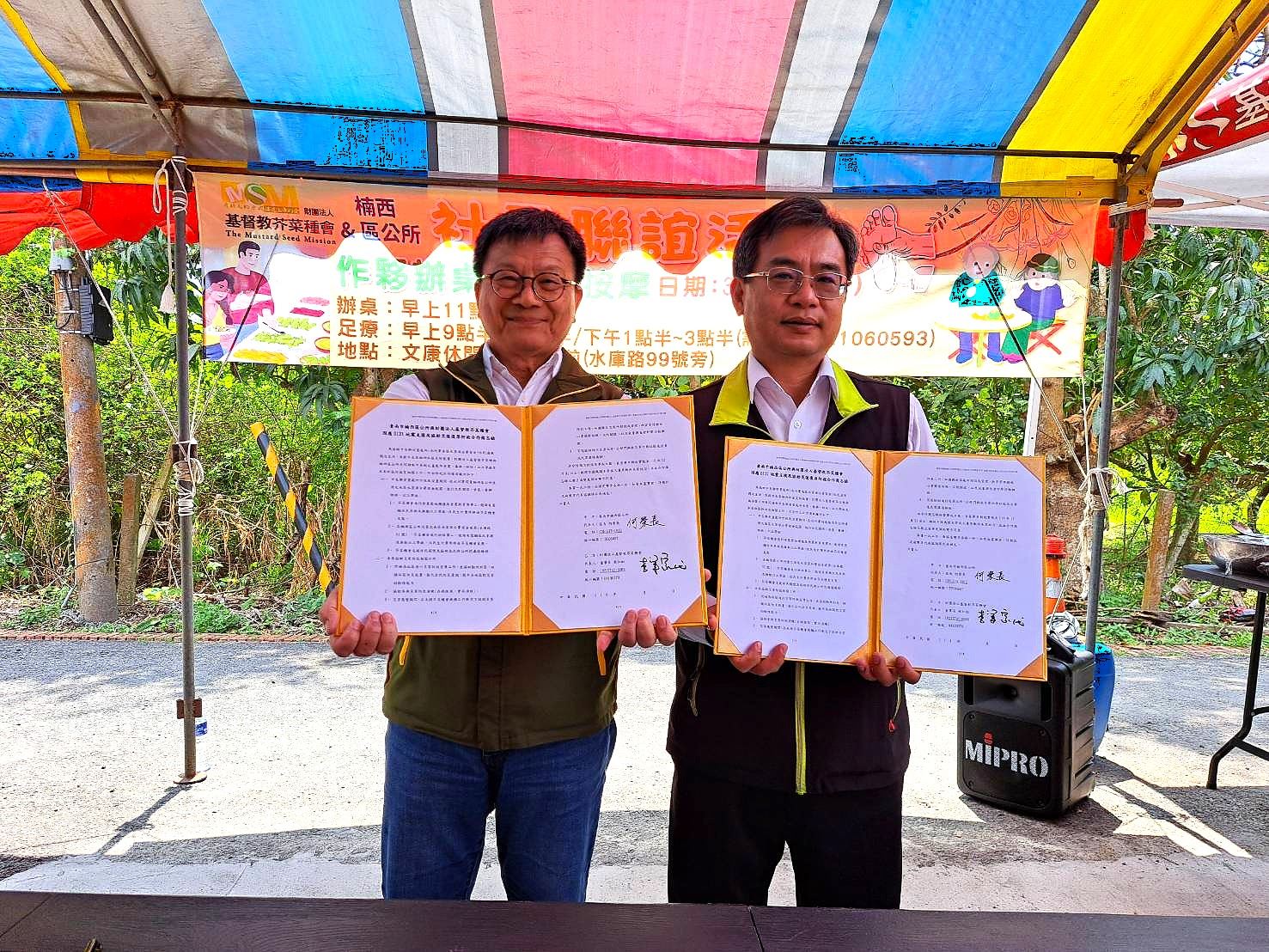芥菜種會李肇家執行長(左)與楠西區公所何榮長區長(右)簽屬合作備忘錄，啟動以工「帶振」專案。（芥菜種會提供）