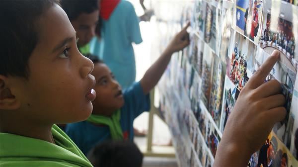 諾魯的孩子正在欣賞廖珮含舉辦的攝影展，從不同的角度看自己的家鄉。