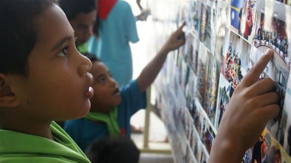 In this photo Narauan children admire works at an exhibition of photos taken by youth ambassadors including Peggy Liao, seeing their own homeland from a new perspective.