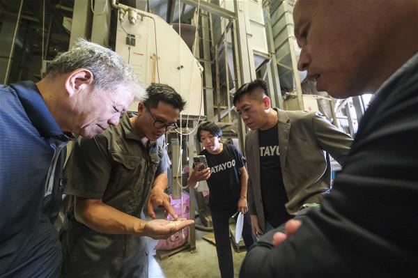 大賀良質米農場營運長陳士賢（左2）向眾人解說挑選米的原則。