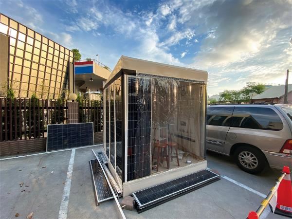 研究團隊以光電建材玻璃搭建太陽能小屋,成功讓屋裡的電器運轉,證明垂直使用太陽能板的可行性。(劉真誠提供)