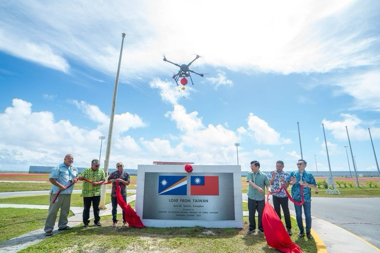 Foreign Minister Lin Chia-lung (third right) is joined by Marshall Islands Minister of Education, Sports and Training Gerald Zackios (third left) in unveiling a commemorative plaque at Jenrok Sports Complex during his April 7-9 visit to the Pacific ally. (MOFA)
