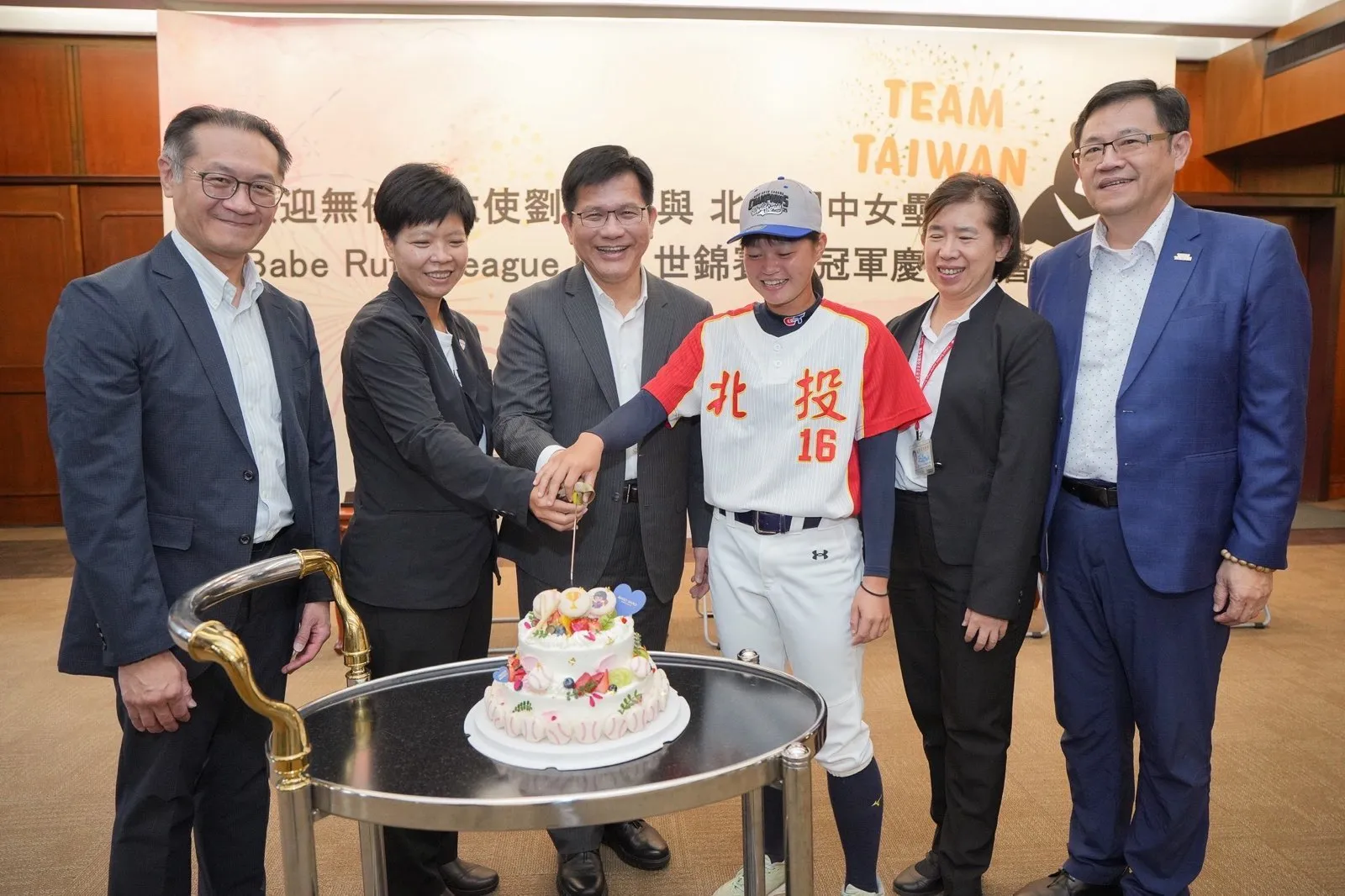 外交部長林佳龍（左三）、無任所大使劉柏君（左二）及女壘隊選手郭俐妤（右三）共同切蛋糕慶賀奪冠。