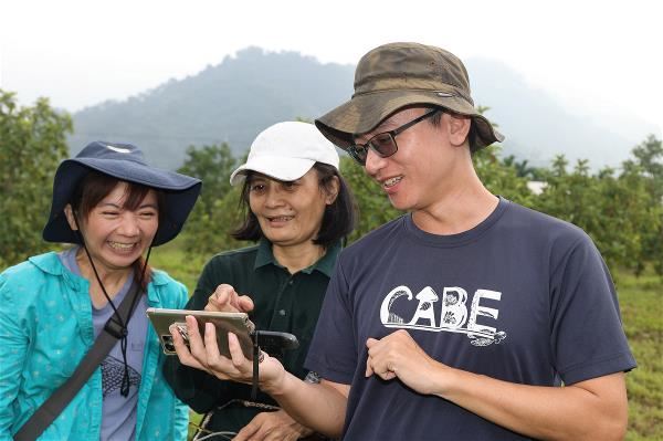 果農李淑萍（中）設置棲架，拍到黑翅鳶、藍磯鶇，將成果分享給客人與在德國的乾爸、乾媽。