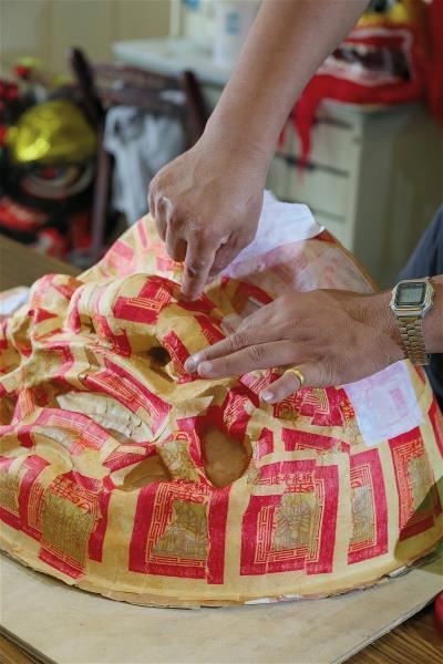 Making a lion head is a complicated process that takes months to complete. In one important step, glutinous rice flour and tapioca starch are mixed into a natural paste that is used to glue on ghost money. After the head-in-progress is dried in the sun, this step is repeated four more times.
