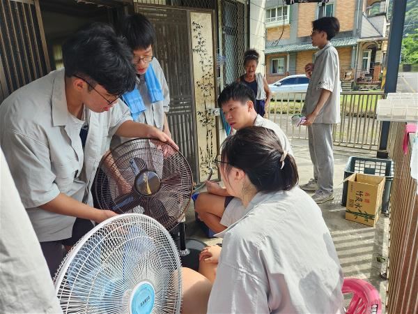 大學教育正從專業學術的殿堂,逐漸轉型為推動在地社區乃至國際社會邁向永續發展的重要動能之一。圖為台科大「行動工程師」計畫中,學生發揮工科專長,為社區居民提供電器維修服務。(台科大提供)