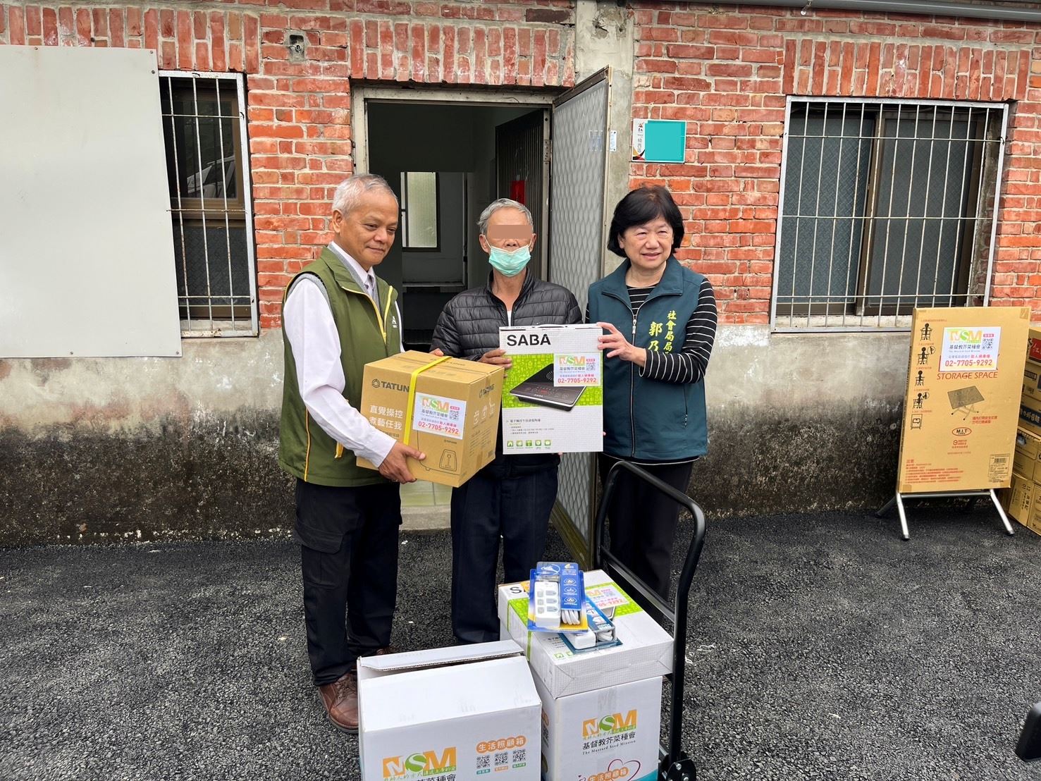 芥菜種會為第一批入住民眾預備生活物資，由芥菜種會全國成處長(圖左)代表贈送。圖右為台南市政府社會局郭乃文局長。(芥菜種會提供)