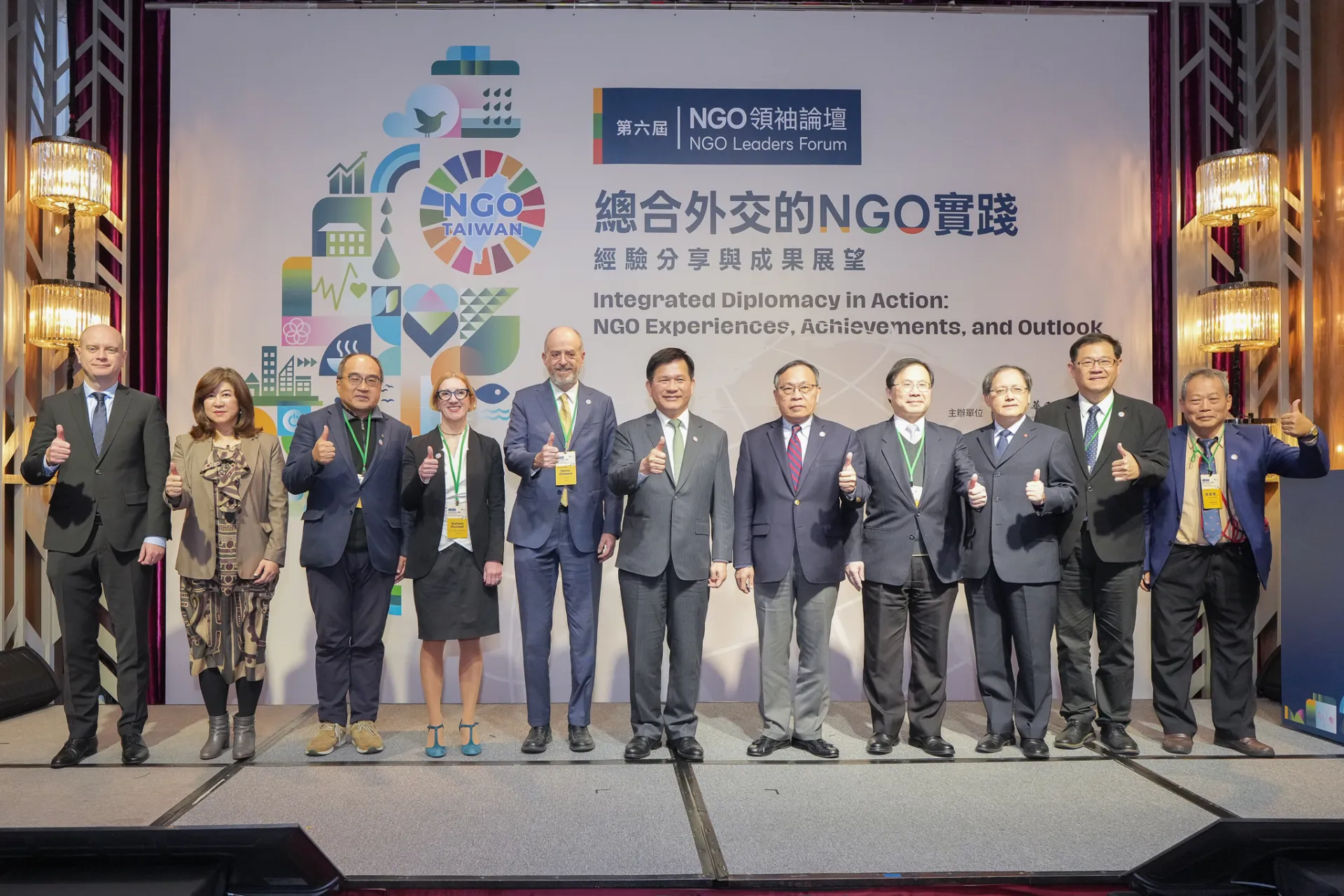 外交部長林佳龍與「經濟外交」場次講者及貴賓合影（由左至右：波蘭臺北辦事處處長雅努什．畢爾斯基（Janusz Henryk Bilski）、大肚山產業創新基金會執行長廖紫岑、中華民國全國工業總會秘書長呂正華、WeWorld處長碧琪奈莉（Stefania Piccinelli）、主席奇耶薩拉、外交部長林佳龍、中華民國國際經濟合作協會理事長呂桔誠、台灣區電機電子工業同業公會秘書長林全能、中華民國對外貿易發展協會秘書長王熙蒙、外交部非政府組織國際事務會執行長江振瑋、公民監督國會聯盟理事長謝東儒）。