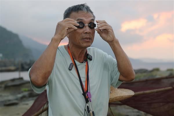 資深海男王瑞吉介紹他的下海行頭，並分享他與海共生的幾十年經驗。下圖為王瑞吉展示昔日曬漁網的景象。