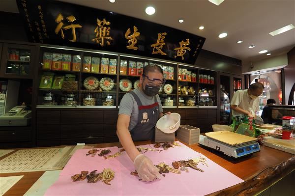 Older customers make a special trip to Huang Chang Sheng Traditional Chinese Pharmacy to see their prescriptions being made up. The ritualistic process imparts a benevolent atmosphere.