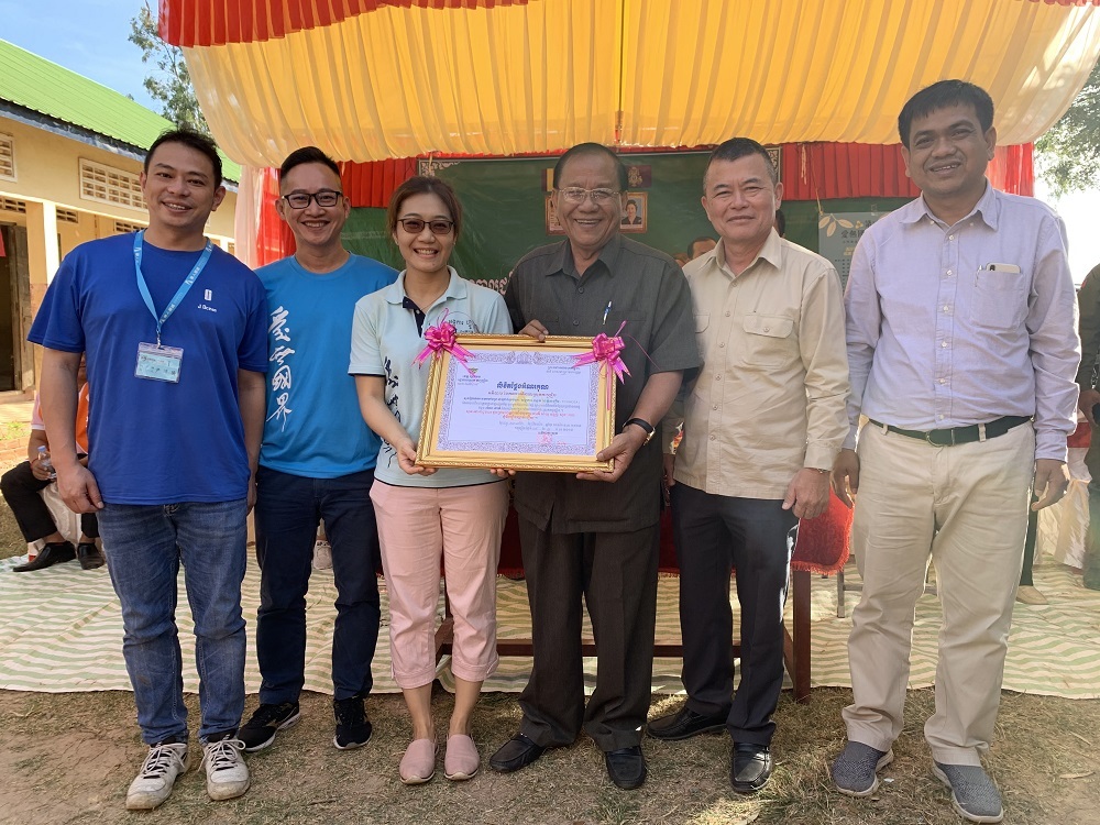 國務秘書Mr.Sov Souvth(中)及Kouk Kong Kaeut縣縣長(右一)感謝希望之芽協會為Theam Nimith小學蓋三間廁所，讓學校有好的衛生環境，特頒感謝狀，由執行長余慈薰(左三)代表接受感謝。